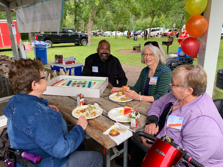 Four people eating at an outdoor event